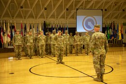 Lt. Col. Christopher Rozhon, Strategic Operations and Plans (SOaP) chief of operations, 1st Theater Sustainment Command (TSC), salutes Col. Rodney Honeycutt, chief of staff, 1st TSC, during a deployment ceremony held Nov. 26, 2019 at Sadowski Center, Fort Knox, Ky.