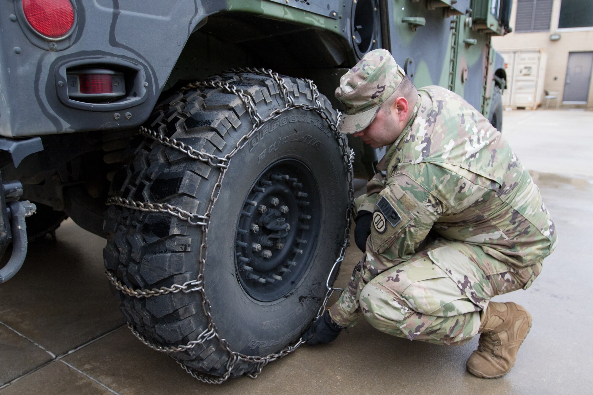 Sgt. Dannie Green, 128th Military Police Company, Alabama National Guard, installs snow chains on Humvees in preparation for winter storm response in Fort Payne, Alabama, Jan.6, 2017. (Photo by Army Sgt. William Frye.)