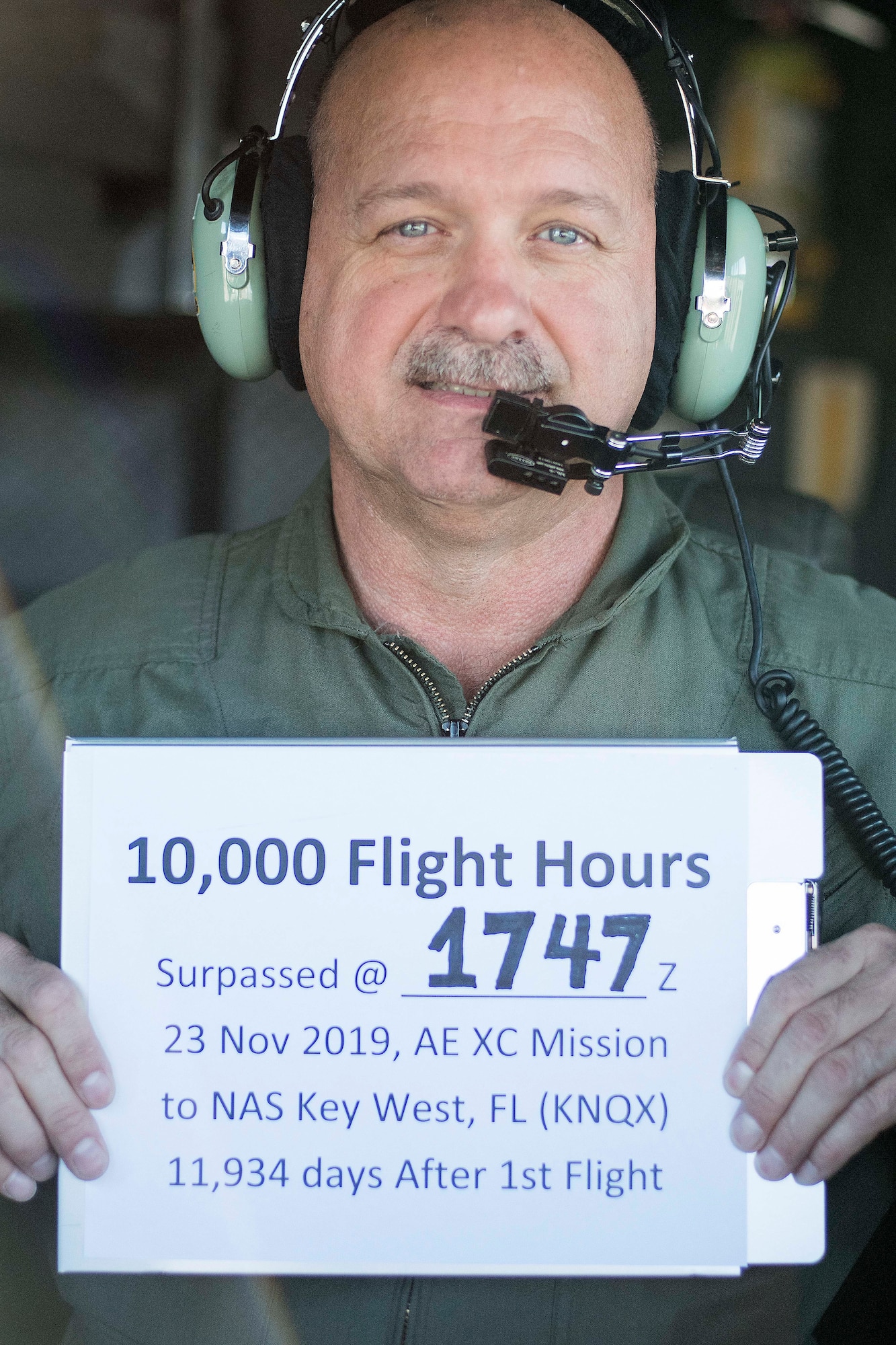 Chief Master Sgt. Terry Studstill, 700th Airlift Squadron flight engineer superintendent, poses with a sign showing the time and location where he attained 10,000 flight hours. He accomplished this major milestone Nov. 23, 2019 on a C-130H3 Hercules bound for Key West, Florida. (U.S. Air Force photo/Tech. Sgt. Andrew Park)
