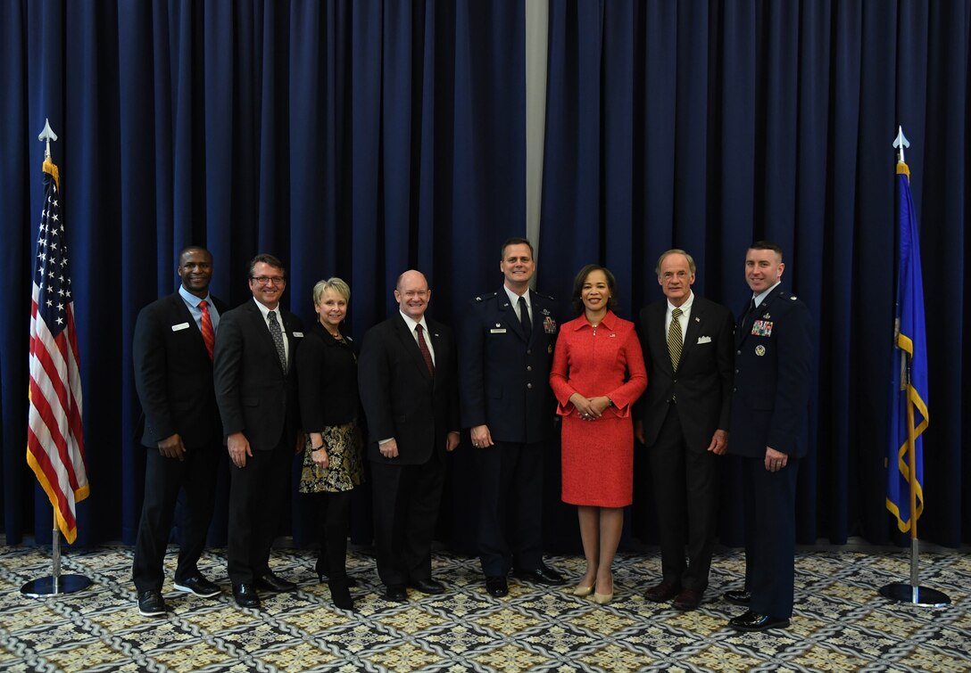 (From left) Evans Armantrading, Central Delaware Chamber of Commerce Military Affairs vice chairman; Shane Breakie, CDCC chairman; Judy Diogo, CDCC president; U.S. Senator Chris Coons; Col. Joel Safranek, 436th Airlift Wing commander; U.S. Rep. Lisa Blunt Rochester; U.S. Senator Tom Carper and Lt. Col. Robin Ryan, 512th Mission Support Group commander, pose for a photo following the State of the Base on Dover Air Force Base, Del., Nov. 25, 2019. (U.S. Air Force photo by Senior Airman Eric M. Fisher)
