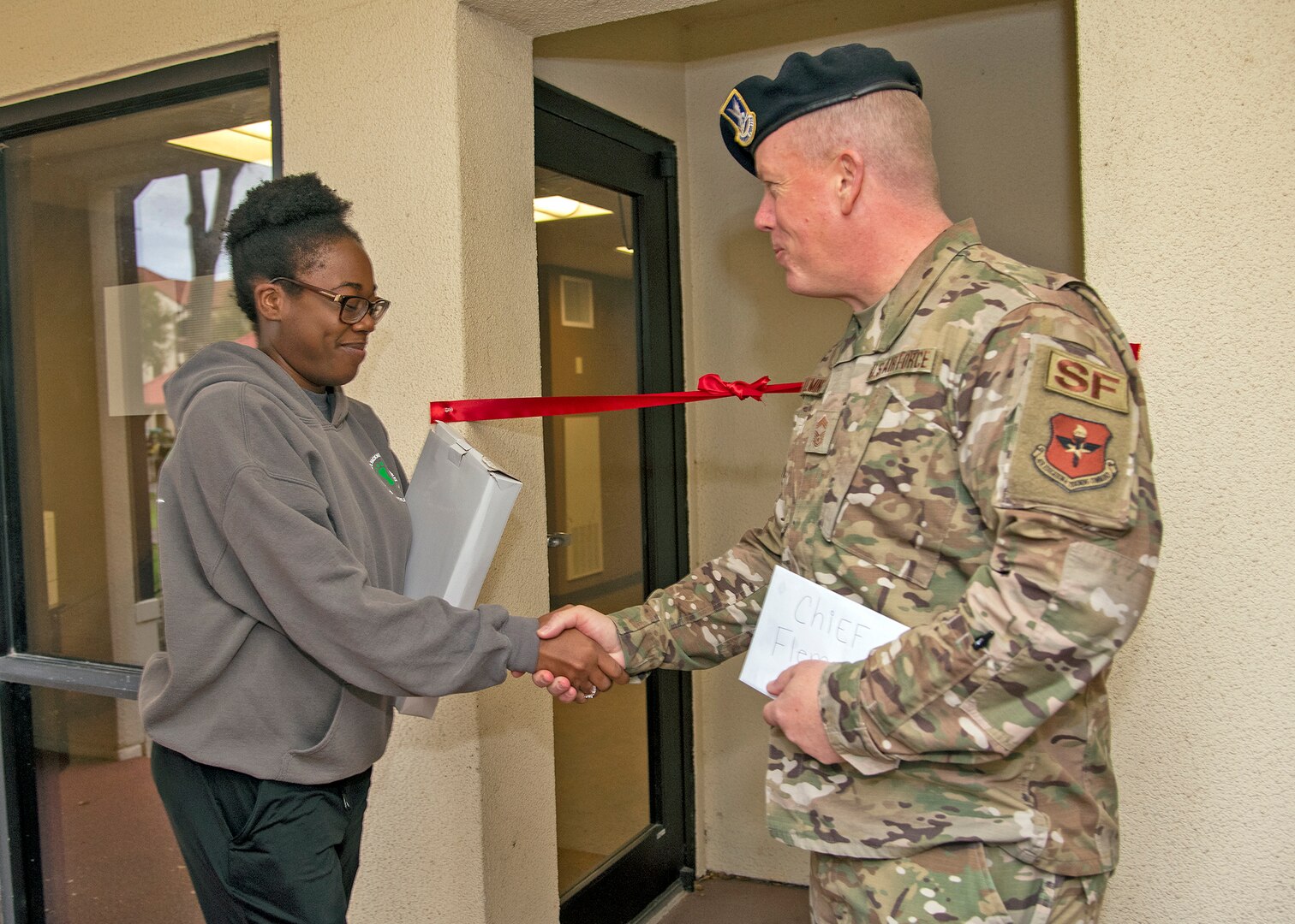 Airman 1st Class Amelia Franklin, dorm council president shakes hand with Chief Master Sgt. Anthony Fleming, 502nd Security Forces Group Command Chief at the entrance to the dorm’s new Airman Learning Center at the dorms, November 22, 2019, Joint Base San Antonio-Randolph, Texas. The learning center features two Air Force network computers and a printer.