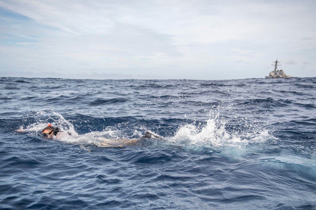 A sailor swims through waters.