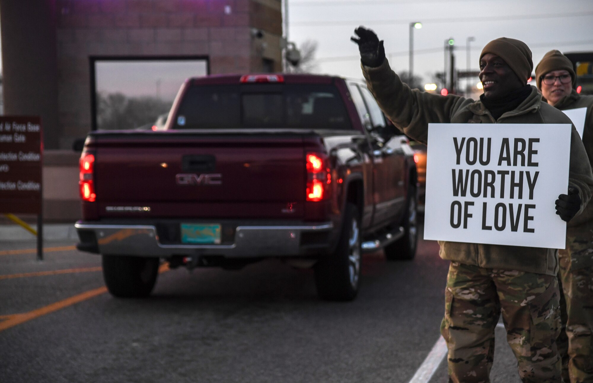 Photo of individual holding sign that says "You are worthy of love."