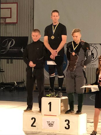 A photo of Lt. Col. Robert G. Childs, 234th Intelligence Squadron commander standing atop a medal podium after winning a sword fighting competition
