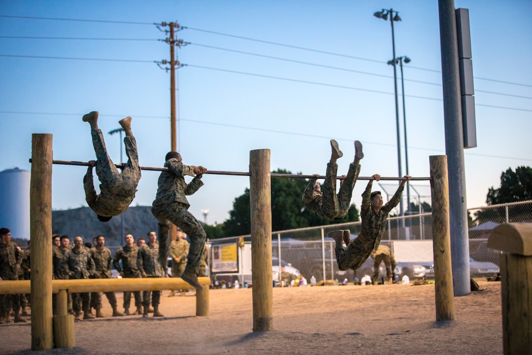 U.S. Marines and Sailors with Headuarters and Headquarters Squadron, Marine Corps Air Staion (MCAS) Yuma, participate in a squadron-wide obstacle course exercise on Nov. 8, 2019. The Marine Corps obstacle course is composed of various obstacles such as high and low logs, high bars, incline bars and traverse logs, and a rope climb. (Marine Corps photo by Lance Cpl. John Hall)