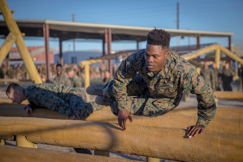 U.S. Marines and Sailors with Headuarters and Headquarters Squadron, Marine Corps Air Staion (MCAS) Yuma, participate in a squadron-wide obstacle course exercise on Nov. 8, 2019. The Marine Corps obstacle course is composed of various obstacles such as high and low logs, high bars, incline bars and traverse logs, and a rope climb. (Marine Corps photo by Lance Cpl. John Hall)