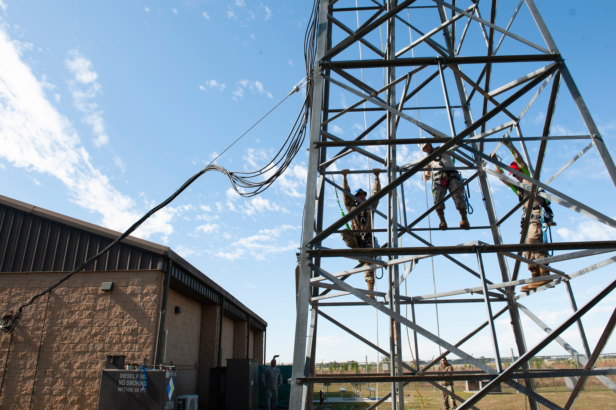 A photo of Airmen climbing a radio tower