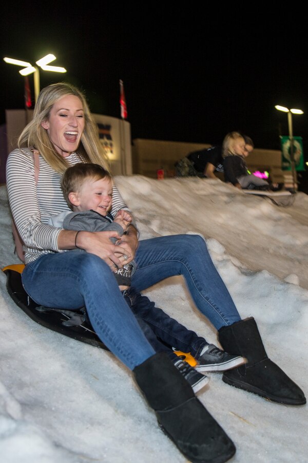 Attendees of the 2019 Tree Lighting Celebration sled down a snowy hill at the Pacific Views Marine Corps Exchange on Marine Corps Base Camp Pendleton, California, Nov. 23, 2019. The 50 foot holiday tree has over 30,000 twinkling lights and has been used for the past five years. The event also consists of a children’s carnival with games and rides, various sweepstakes, Santa and Mrs. Clause. (U.S. Marine Corps photo by Lance Cpl. Angela Wilcox)