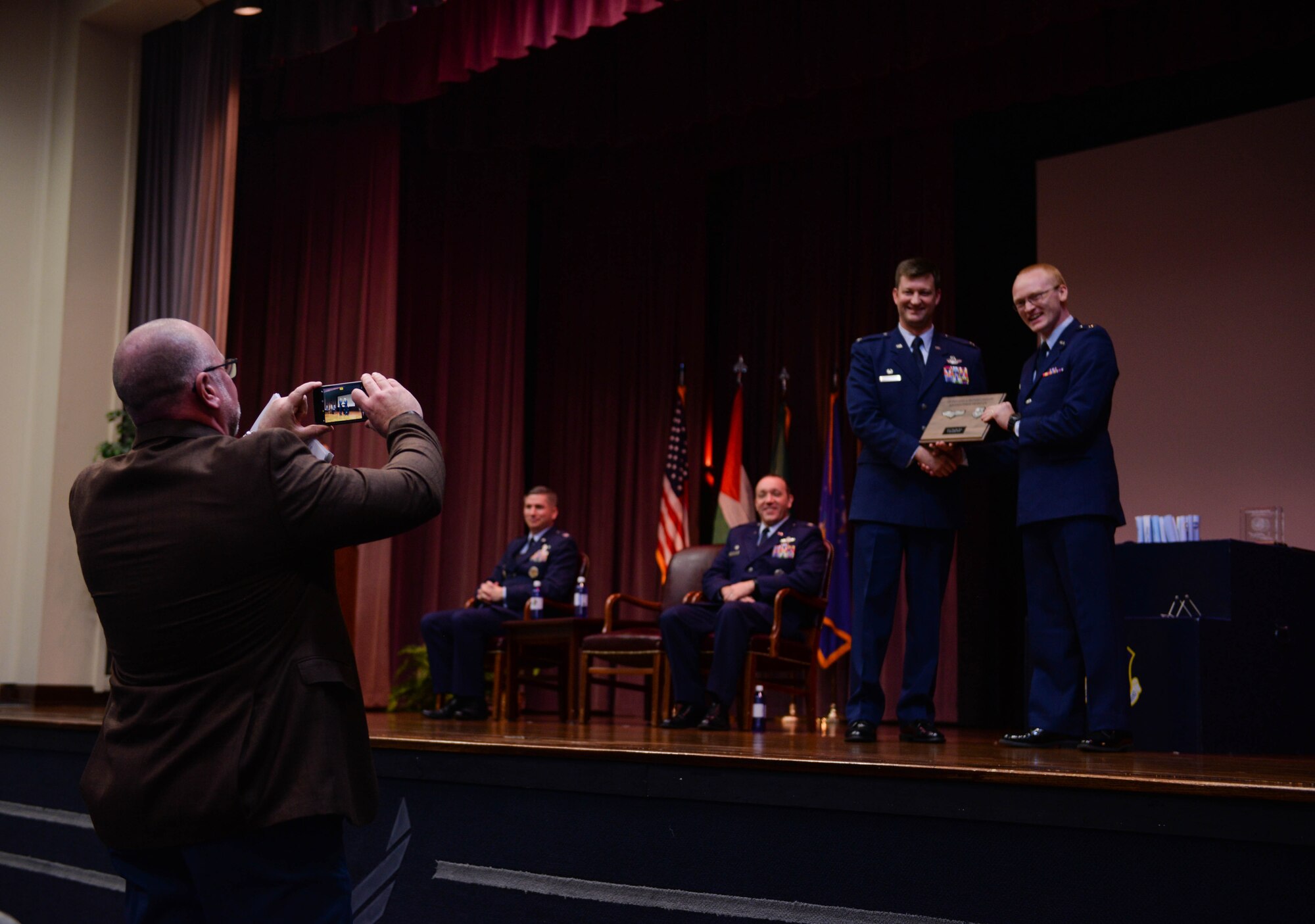 Col. Clinton ZumBrunnen, 437th Airlift Wing commander at Joint Base Charleston, South Carolina, takes a photo with a graduate from Specialized Undergraduate Pilot Training Class 20-03 while family members take photos Nov. 15, 2019, at Columbus Air Force Base, Miss. ZumBrunnen was the guest speaker for SUPT Class 20-03’s graduation ceremony. (U.S. Air Force photo by Airman Davis Donaldson)