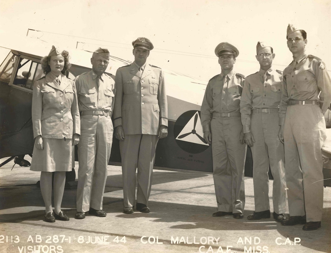 Lt. Col. J. Robert Dowd, Civil Air Patrol wing commander in Mississippi, was met by Col. L.C. Mallory, Columbus Army Air Field commanding officer, and a group of local CAP members when he landed at the Columbus Base to visit the city and address the Kiwanis Club at the Hotel Gilmer. (Left to right) Ida Billups (Ward), first female to make a solo flight with the Columbus Unit of CAP; Col. Mallory; Lt. Col. Dowd; Lt. Ralph Webb, CAP squadron commander in the district, and Sgts. Jack Parker and Billy Furr of the Columbus CAP squadron. (Photo courtesy of Civil Air Patrol)