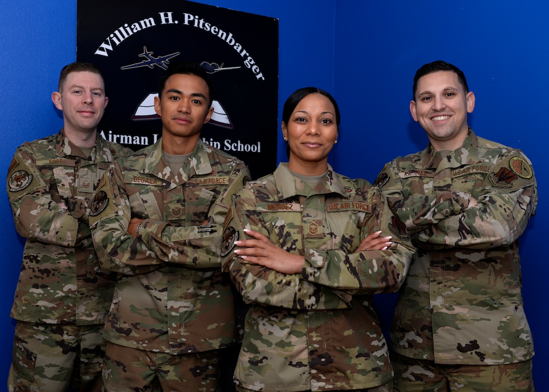 Four Airmen Leadership School instructors pose for a photo