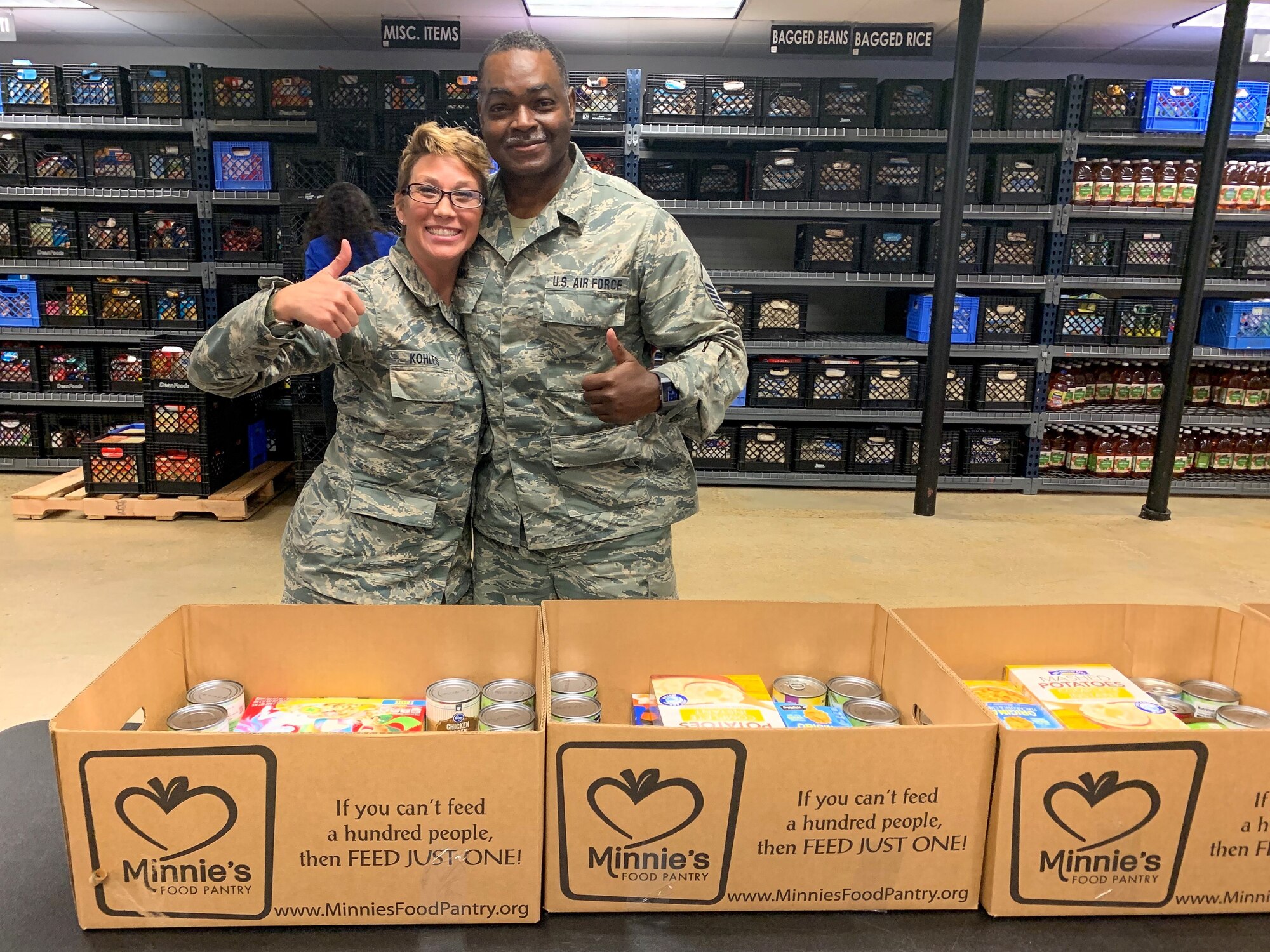 Senior Airman Leilani Kohles, assigned to the 136th Airlift Wing Air National Guard, and Master Sergeant Alan Shankle, assigned to the 301st Fighter Wing Maintenance Squadron, both from Naval Air Station Fort Worth Joint Reserve Base, Texas, pause after working hard with 20 other servicemembers who put together 500 meal packages to be delivered to veterans in need for the holiday season during the Hoops for Troops event November 5, 2019 at Minnie's Food Pantry in Plano, Texas.  Meal packages consisted of non-perishable food items and treats for the veterans to enjoy. (U.S. Air Force photo by Capt. Jessica Gross)