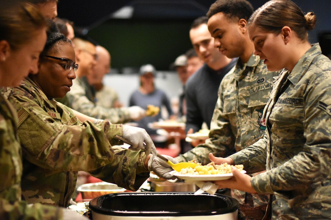 Team BLAZE members gather together for the single Airmen's Dormsgiving and Hearts Apart holiday meal Nov. 26, 2019, on Columbus Air Force Base, Miss. This year single junior enlisted members and families of deployed Airmen gathered with wing leaders to eat an early Thanksgiving style meal to connect. (U.S. Air Force photo by Senior Airman Keith Holcomb)