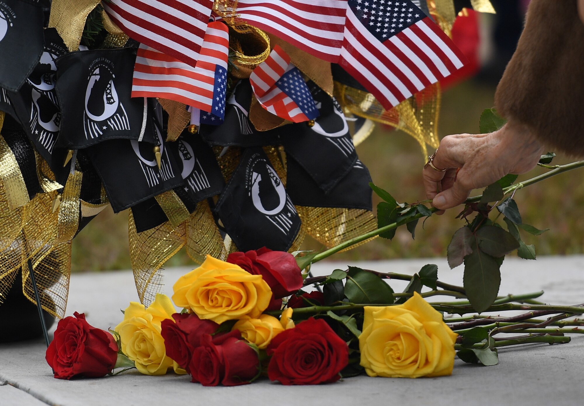 Gold Star family members place roses at the base of a wreath during the Gold Star Families Memorial Monument dedication ceremony at Guice Veterans Memorial Park in Biloxi, Mississippi, Nov. 23, 2019. The monument honors families of service men and women who sacrificed their lives while serving in the military. (U.S. Air Force photo by Kemberly Groue)