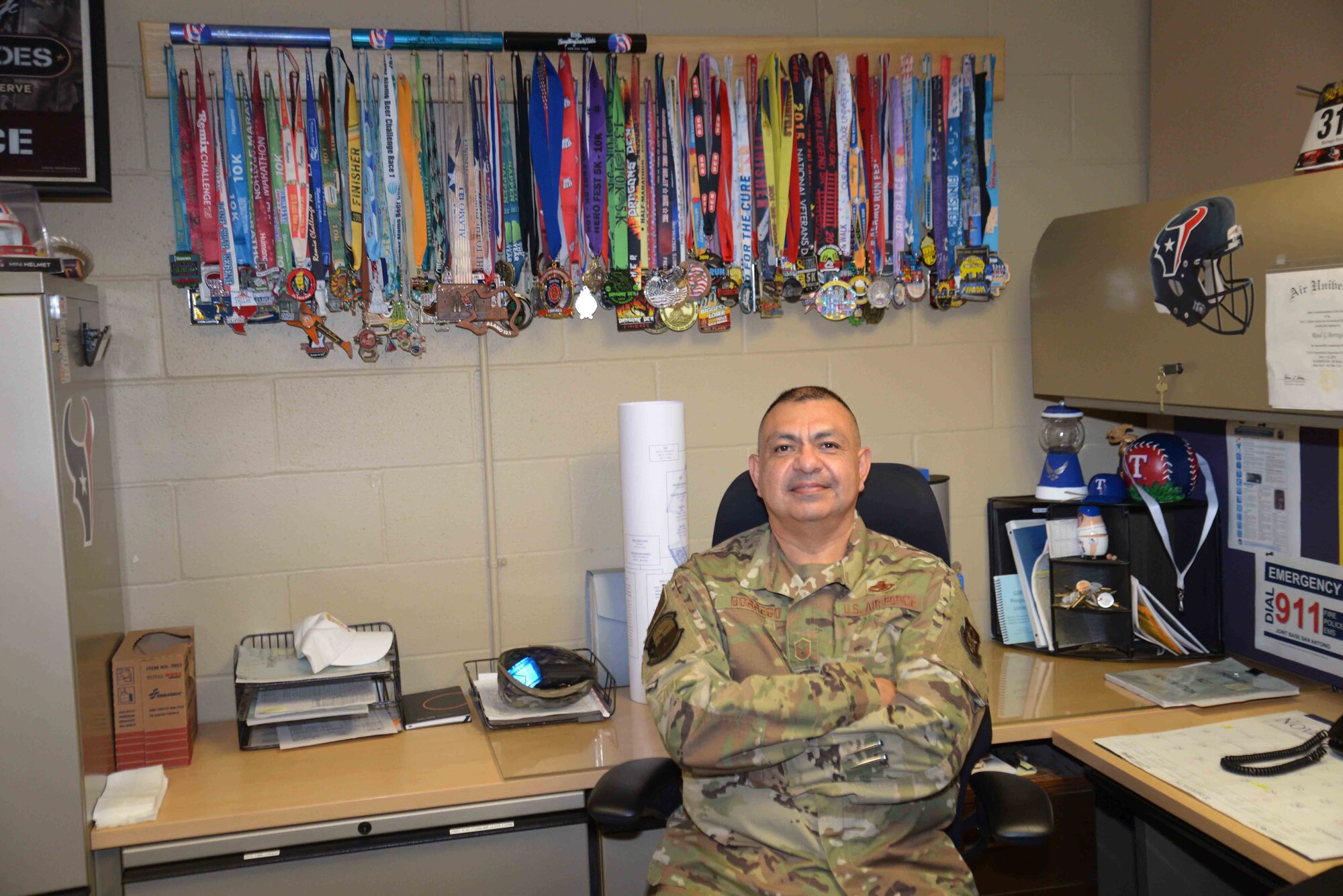 With his finisher medals in the background, Master Sgt. Raul Borrego, 433rd Aircraft Maintenance Squadron aircraft mechanic supervisor, is one of the Reserve Citizen Airmen that Chief Master Sgt. Pedro Saenz, 433rd Aircraft Maintenance superintendent, provides with support regarding his battle with Type 2 diabetes.