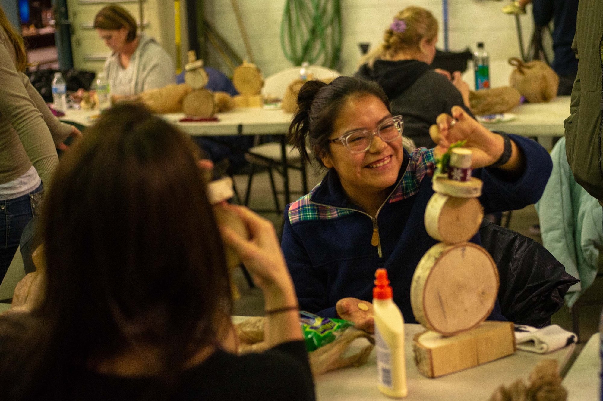 A 354th Logistics Readiness Squadron family member builds a birch snowman at Eielson Air Force Base, Alaska, Nov. 7, 2019. Airmen and families of the 354th LRS gathered to build crafts and relationships during one of their monthly socials. (U.S. Air Force photo by Capt. Kay Nissen)