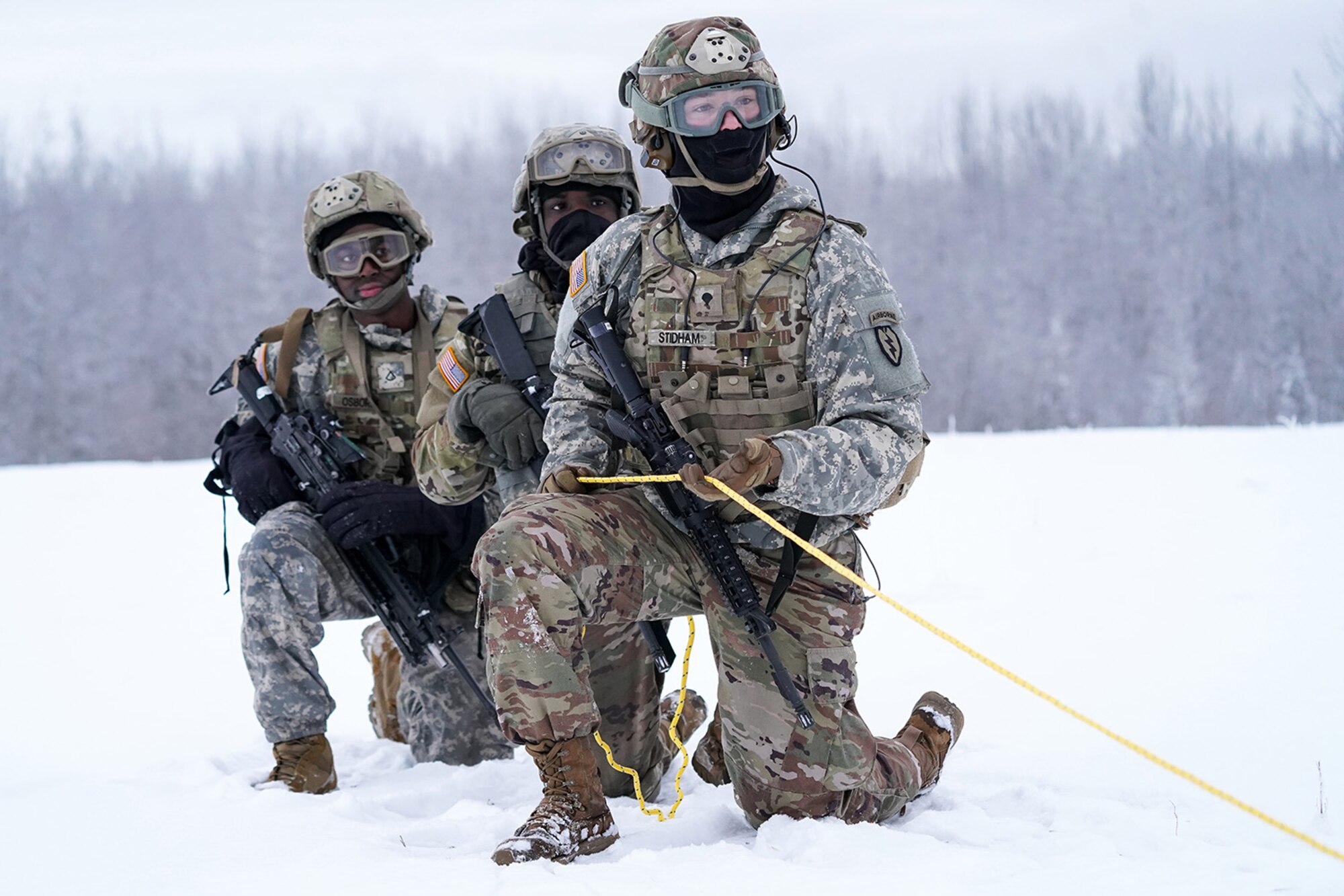 Spc. Eric Stidham assigned to Headquarters and Headquarters Company, 6th Brigade Engineer Battalion (Airborne), 4th Infantry Brigade Combat Team (Airborne), 25th Infantry Division, U.S. Army Alaska, trains with fellow Soldiers and aviators from the Alaska Army National Guard at Neibhur Drop Zone, Nov. 26, 2019, to hone their life-saving and Medevac hoist skills for the paratroopers’ upcoming rotation to the Joint Readiness Training Center at Fort Polk, La.