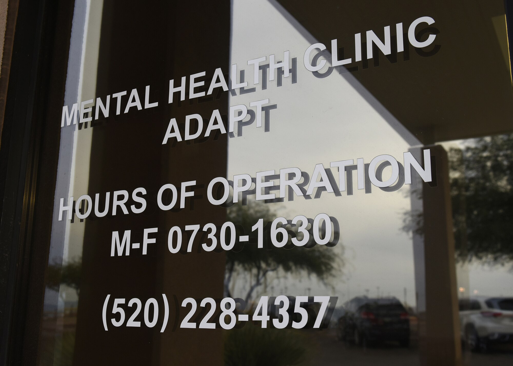 Hours of operation of a mental health clinic are displayed on building window