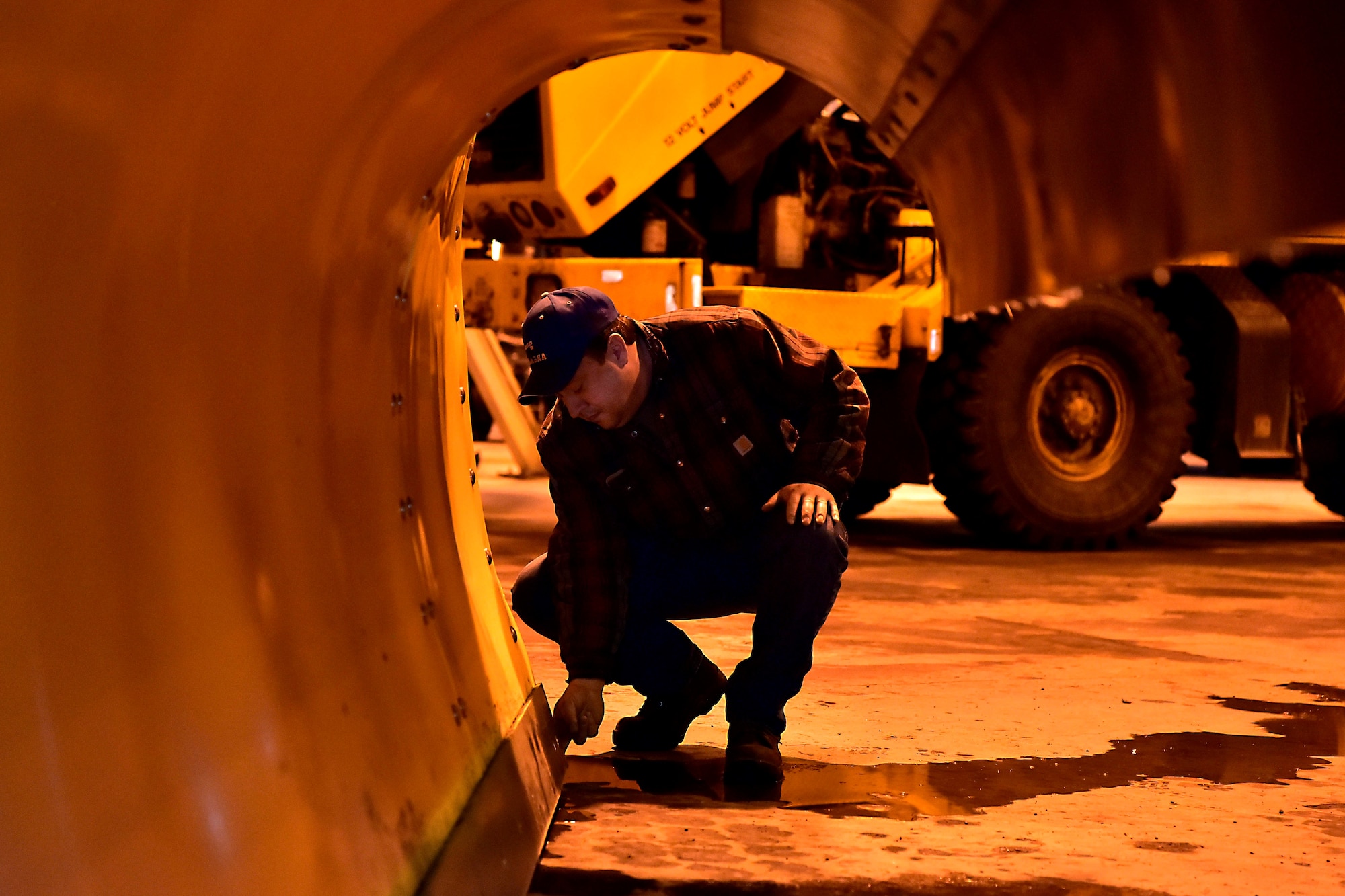 John Kowalski, the 354th Civil Engineer Squadron director of airfield snow removal operations, checks the blade on a plow on Eielson Air Force Base, Alaska, Nov. 21, 2019. Snow barn and vehicle maintenance Airmen work closely together to ensure all equipment is properly maintained due to extensive use and harsh winter conditions. (U.S. Air Force photo by Senior Airman Beaux Hebert)
