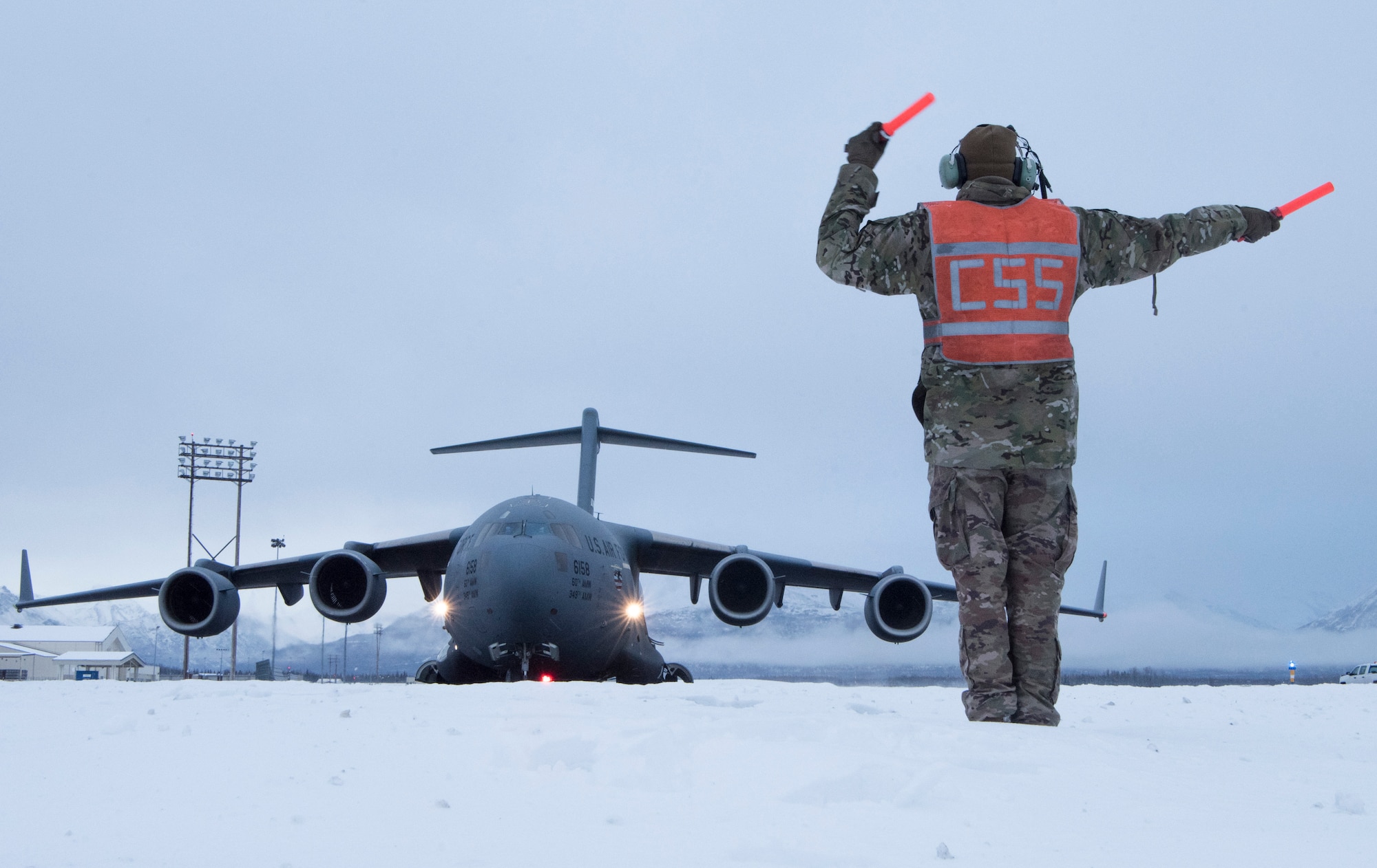 U.S. Air Force Staff Sgt. Joshua Sink, 921st Contingency Response Squadron, contingency response aircraft maintenance craftsman assigned to Travis Air Force Base, Calif., marshals a C-17 Globemaster III assigned to Travis AFB during cold weather aircraft maintenance procedures training at Joint Base Elmendorf-Richardson, Alaska, Nov. 19, 2019. The training prepared Airmen to operate in arctic environments.