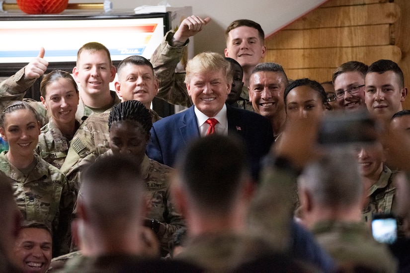 President Donald J. Trump poses for a photo with troops.