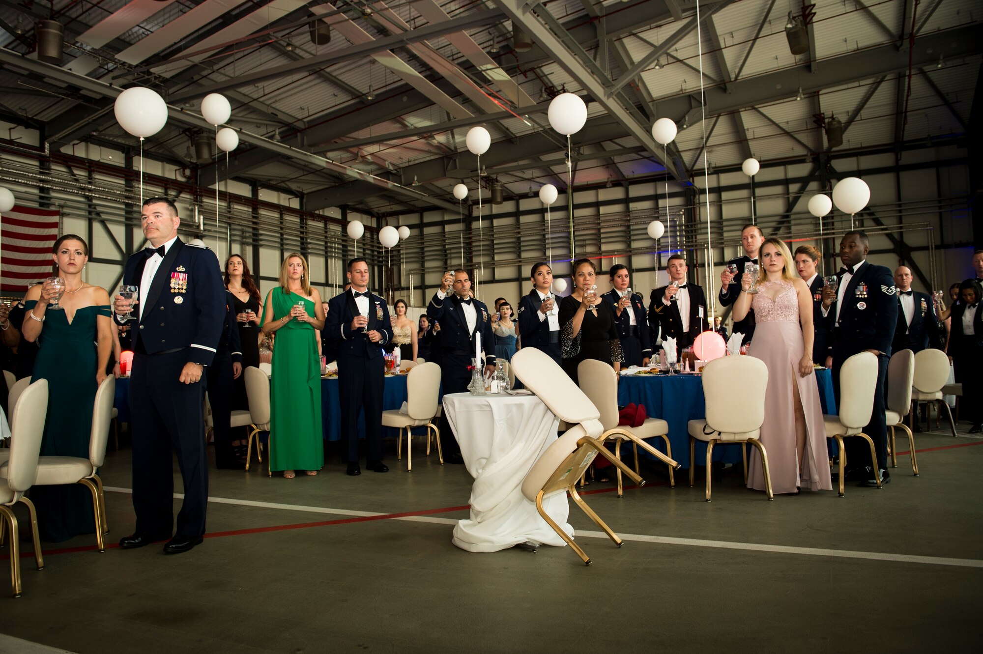 Attendees of the 72nd Air Force birthday ball raise a silent toast to the Prisoners of War and Missing in Action Americans at Ramstein Air Base, Germany, Sept. 21, 2019. During the POW/MIA toast, a glass of water is raised to honor those service members who cannot be at the ball to celebrate with the attendees. (U.S. Air Force photo by Staff Sgt. Jonathan Bass)