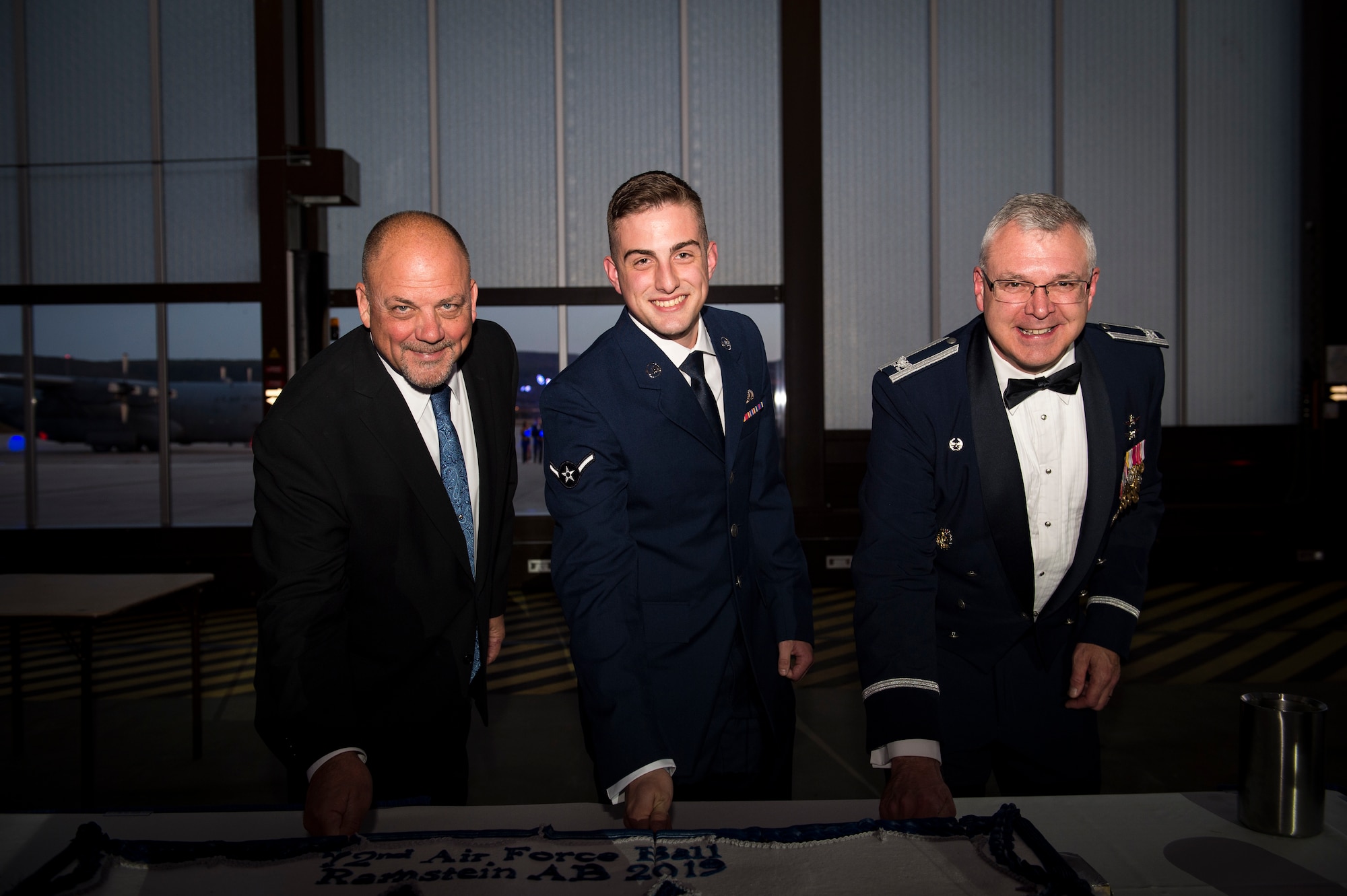Scott C. Lockard, 86th Airlift Wing vice director (left), U.S. Air Force Airman Zackary Treadwell, 86th Maintenance Group (middle), and Col. Robert S. Thompson, 86th Mission Support Group commander (right), cut the birthday cake during the 72nd Air Force birthday ball at Ramstein Air Base, Germany, Sept. 21, 2019. The three people cutting the cake represented different aspects of the Total Force. Lockard represented the civilian force, Treadwell the enlisted force, and Thompson the commissioned force. (U.S. Air Force photo by Staff Sgt. Jonathan Bass)