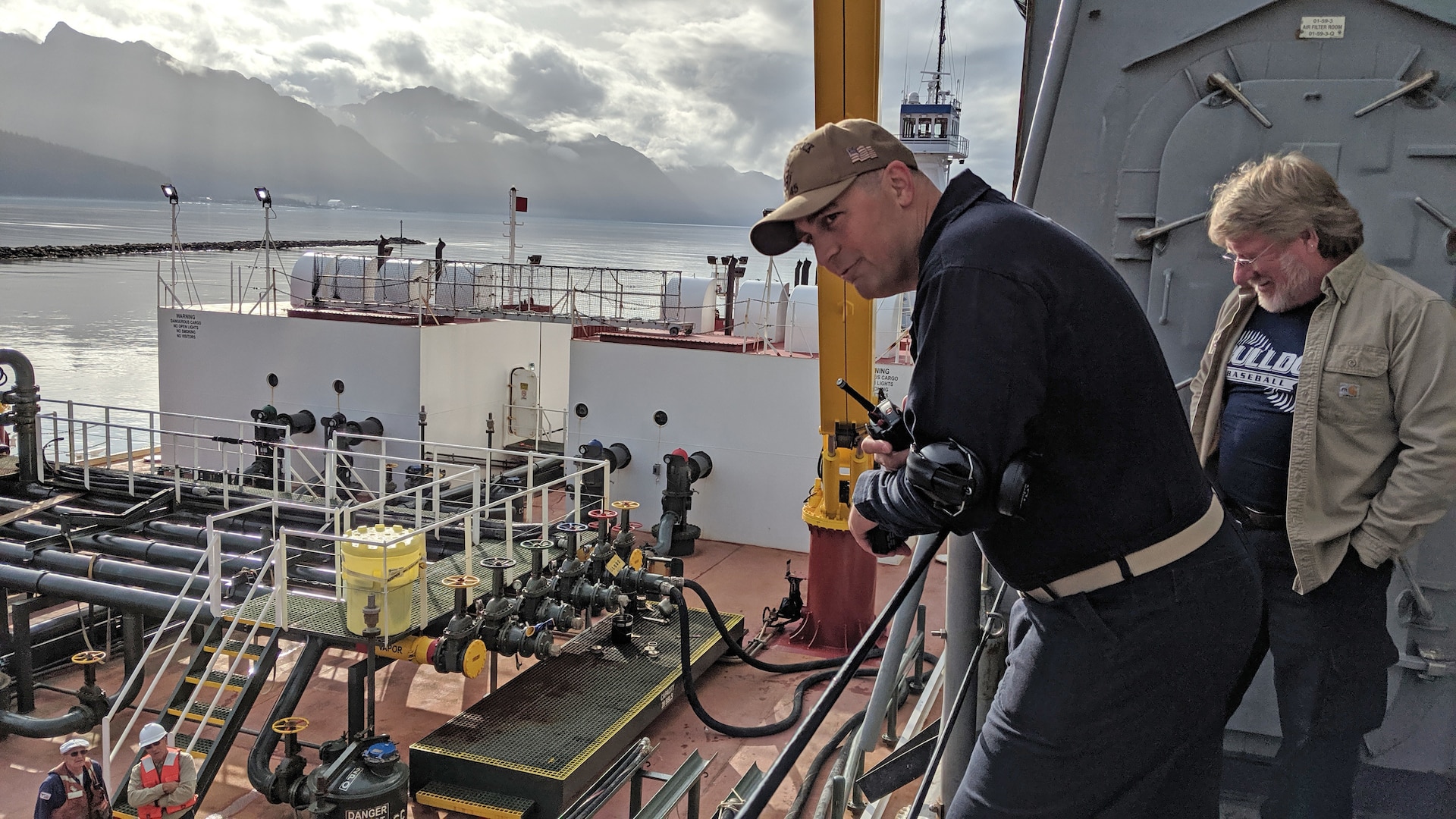men observe refueling operations on a ship