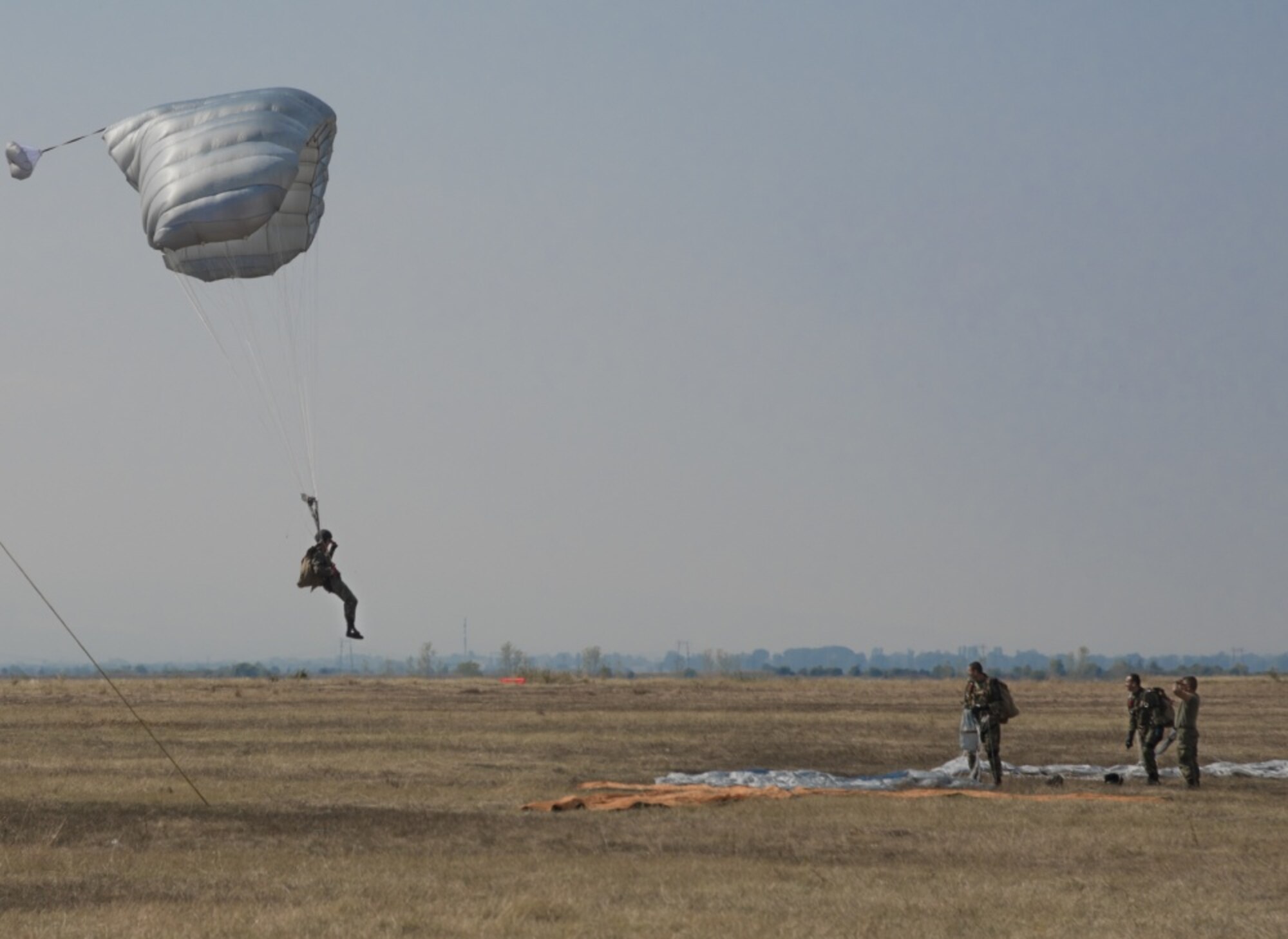 A jumper with Bulgaria’s 68th Special Forces Brigade glides into Cheshnegirovo drop zone in Plovdiv, Bulgaria, Sept. 26, 2019. The students of the military free-fall course, using steerable parachutes, were expected to aim for the large orange tee. (U.S. Air Force photo by Staff Sgt. Kirsten Brandes)