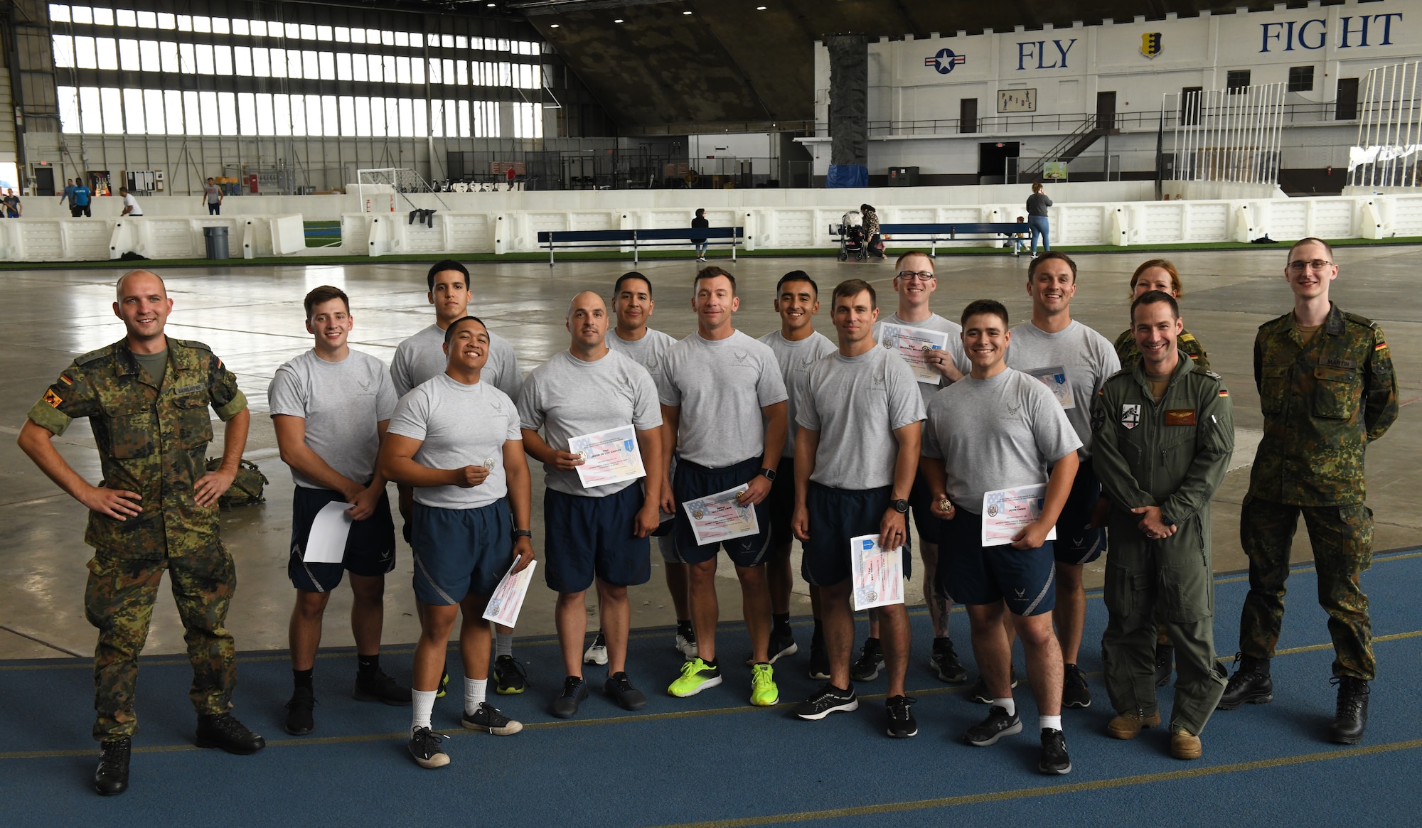 Ellsworth Airmen pose proudly alongside German officers after being awarded their German Armed Forces Proficiency Badges at the Pride Hangar on Ellsworth Air Force Base, S.D., Sept. 21, 2019. Eleven Airmen set out to complete the GAFPB Test and all finished successfully with badges ranging from bronze to gold. The badge is one of the few approved foreign awards that Airmen are permitted to wear on their service dress uniform.  (U.S. Air Force photo by Airman 1st Class Christina Bennett)