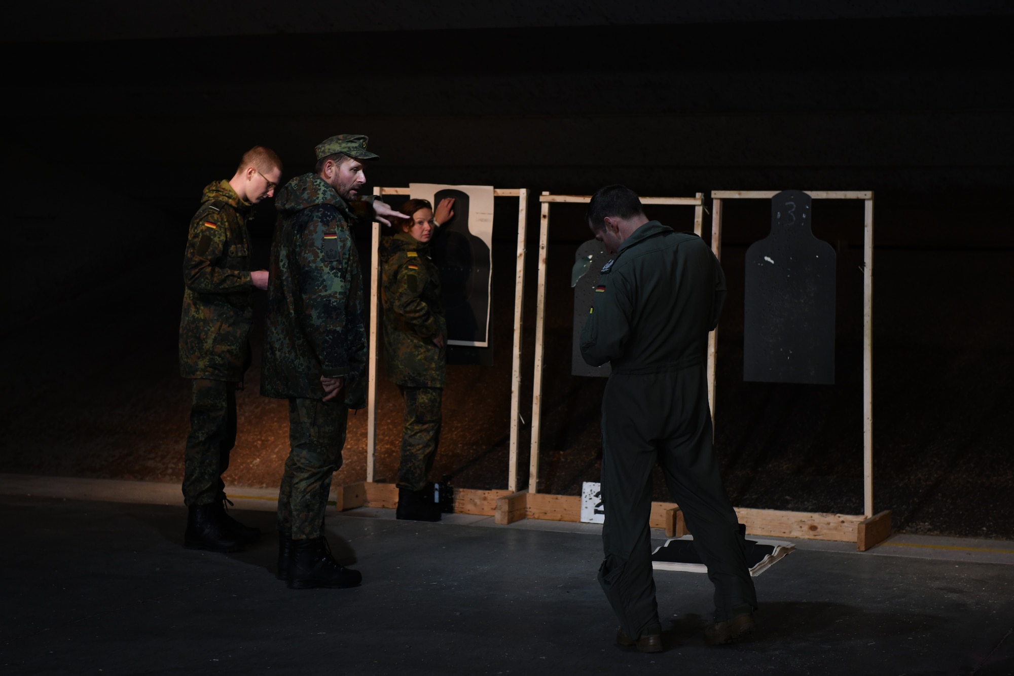 A group of German officers prepare targets for the pistol qualification portion of the German Armed Forces Proficiency Test at the Combat Arms and Maintenance facility at Ellsworth Air Force Base, S.D., Sept. 21, 2019. Participants had to complete six events comprised of a 100-meter swim in uniform, a chin up test, a 1,000-meter run, a sprint test, a pistol qualification test and a 7.46 mile ruck march. (U.S. Air Force photo by Airman 1st Class Christina Bennett)