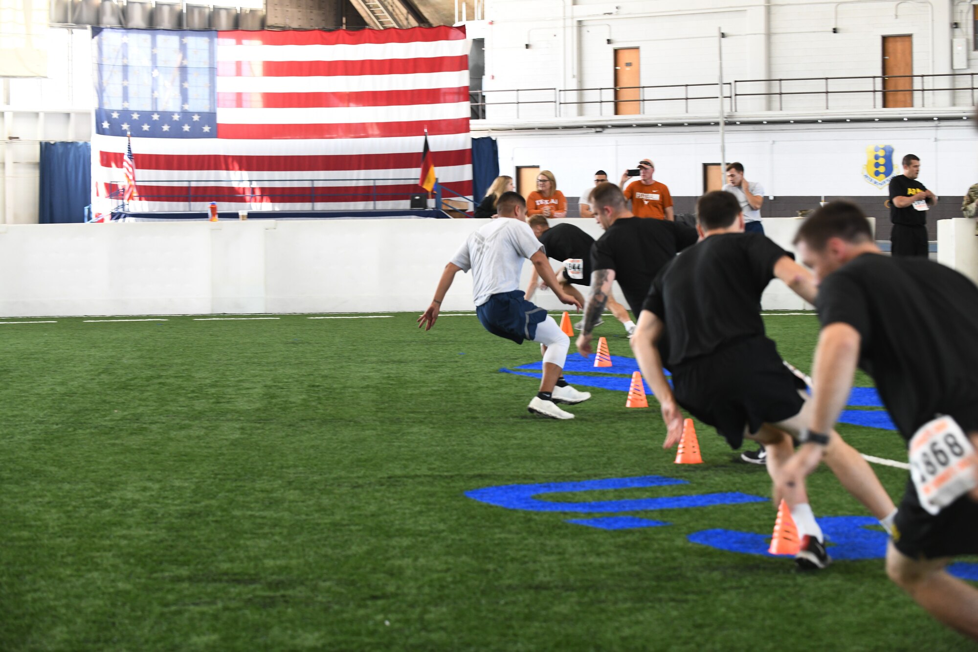 An Airman sprints alongside Army ROTC cadets at the Pride Hangar on Ellsworth Air Force Base, S.D., Sept. 21, 2019. The sprint was one of six events participants had to complete to be awarded the German Armed Forces Badge for Military Proficiency. (U.S. Air Force Photo by Airman 1st Class Christina Bennett)