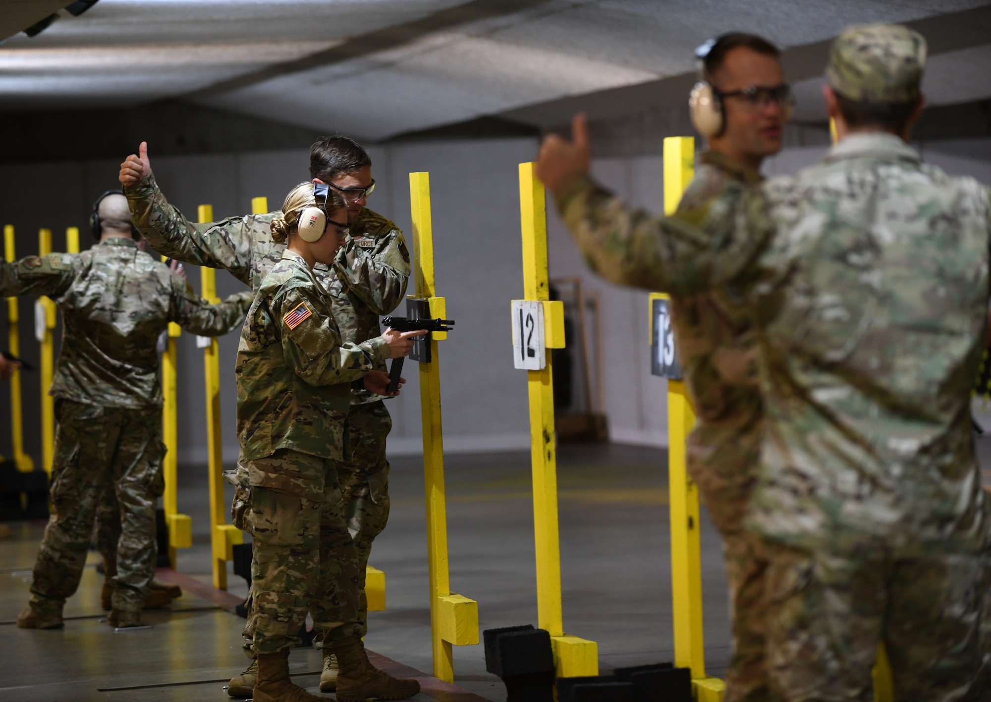 Tech. Sgt. Jason Smith, a 28th Security Forces Squadron unit training manager, assists an Army ROTC cadet during the pistol qualification portion of the German Armed Forces Proficiency Test at the Combat Arms and Maintenance facility at Ellsworth Air Force Base, S.D., Sept. 21, 2019. Smith, who was the liaison between Ellsworth Airmen and the Army ROTC program at the South Dakota School of Mines and Technology, was one of the 11 Airmen whom competed for the coveted German Armed Forces Proficiency Badge. (U.S. Air Force Photo by Airman 1st Class Christina Bennett)