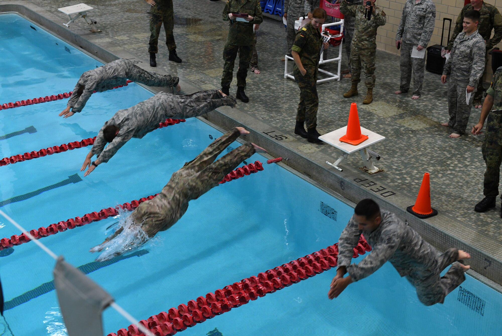 Airmen take a dive during the German Armed Forces Proficiency Test at the Bellamy Fitness Center on Ellsworth Air Force Base, S.D., Sept. 20, 2019. The swimming portion was the first of six events, where contenders had four minutes to swim 100 meters in uniform. (U.S. Air Force photo by Airman 1st Class Christina Bennett)