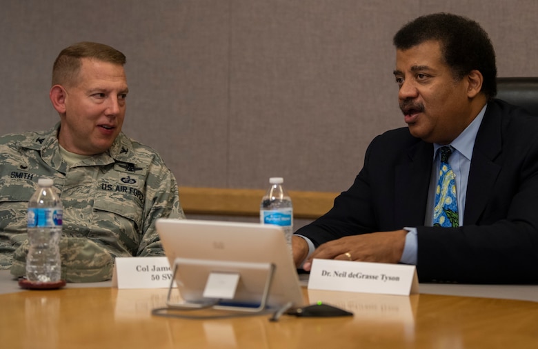Col. James Smith, 50th Space Wing commander, left, talks to Neil DeGrasse Tyson, astrophysicist and author, during a wing mission brief at Schriever Air Force Base, Colorado, Sept 23. 2019. During the mission brief, Tyson learned about the mission, units and mission partners at Schriever AFB. (U.S. Air Force photo by Airman 1st Class Jonathan Whitely)