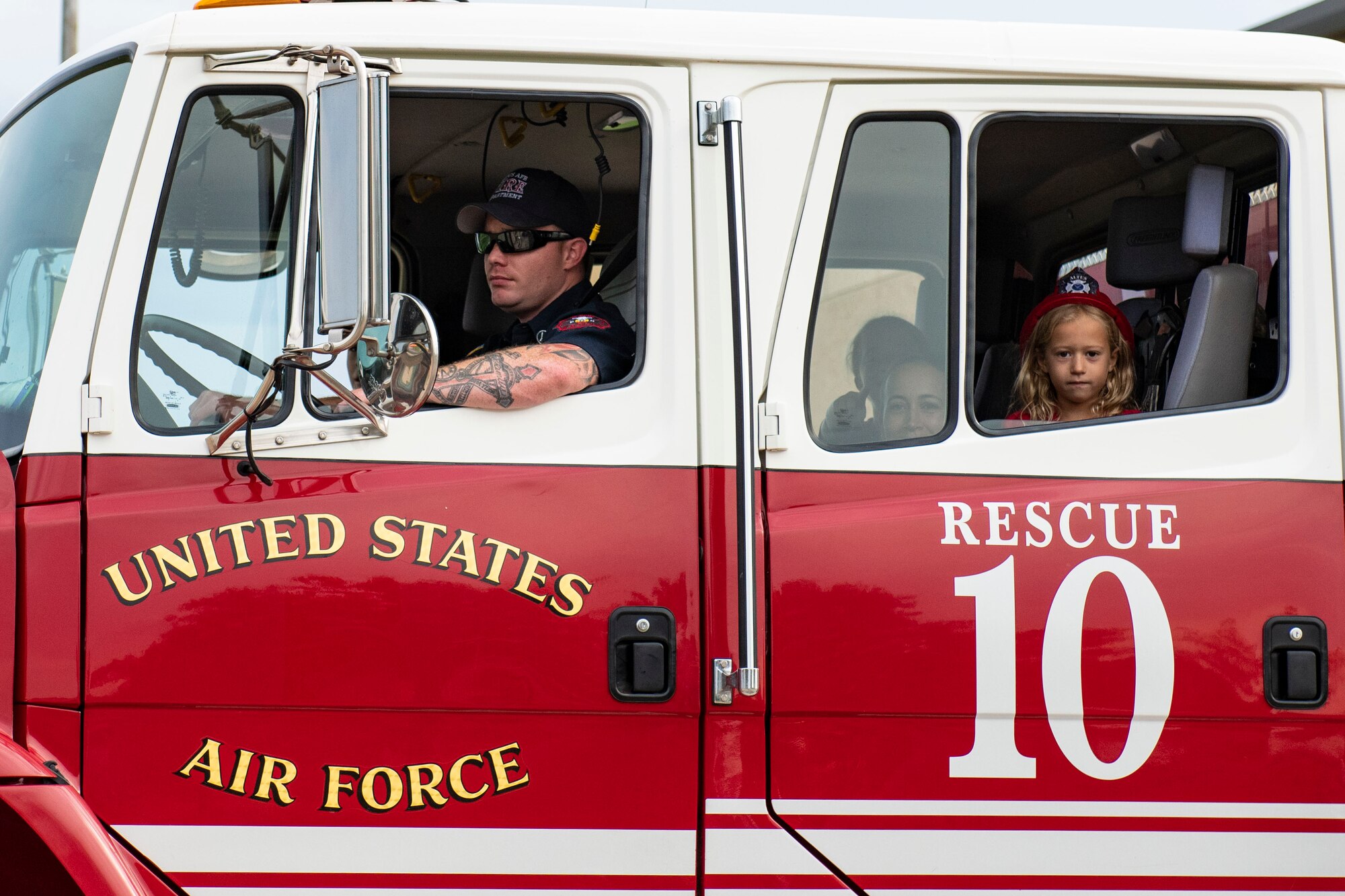 Military children watch the a fire deparptment parade through base housing.