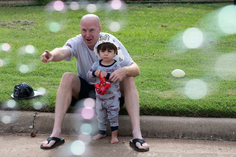 Military children watch the a fire deparptment parade through base housing.