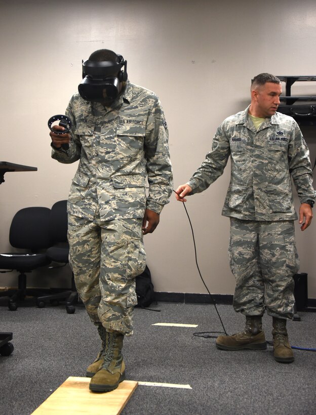 366th Training Squadron electrical systems apprentice course student, steps onto a wooden plank during a virtual reality fear of heights assessment