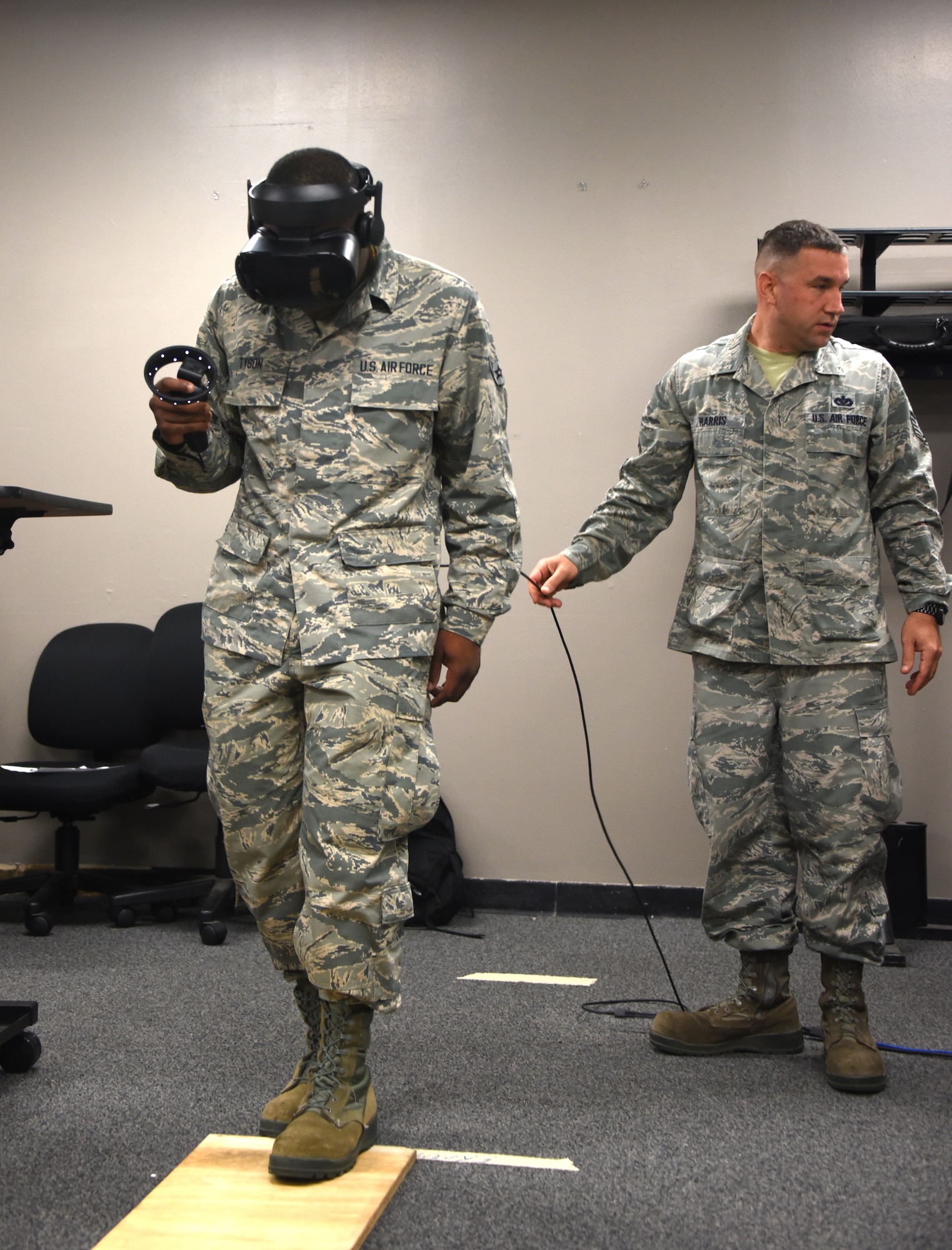 366th Training Squadron electrical systems apprentice course student, steps onto a wooden plank during a virtual reality fear of heights assessment