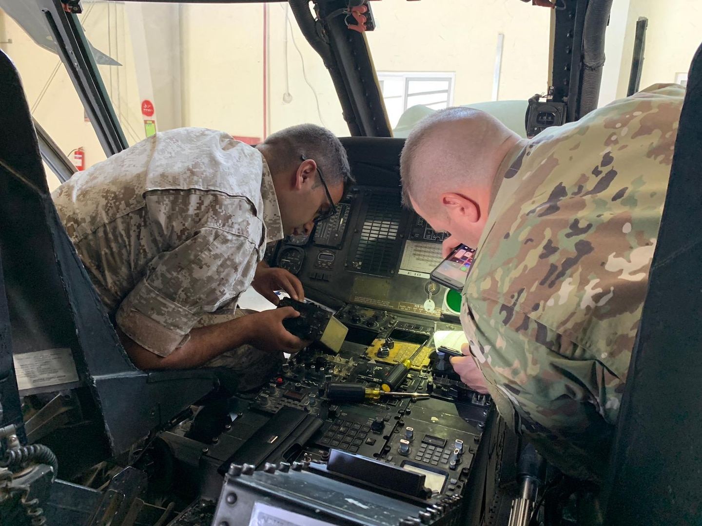 Indiana National Guard Sgt. 1st Class Brain W. Branson talks with a Jordan armed forces service member about helicopter avionics.