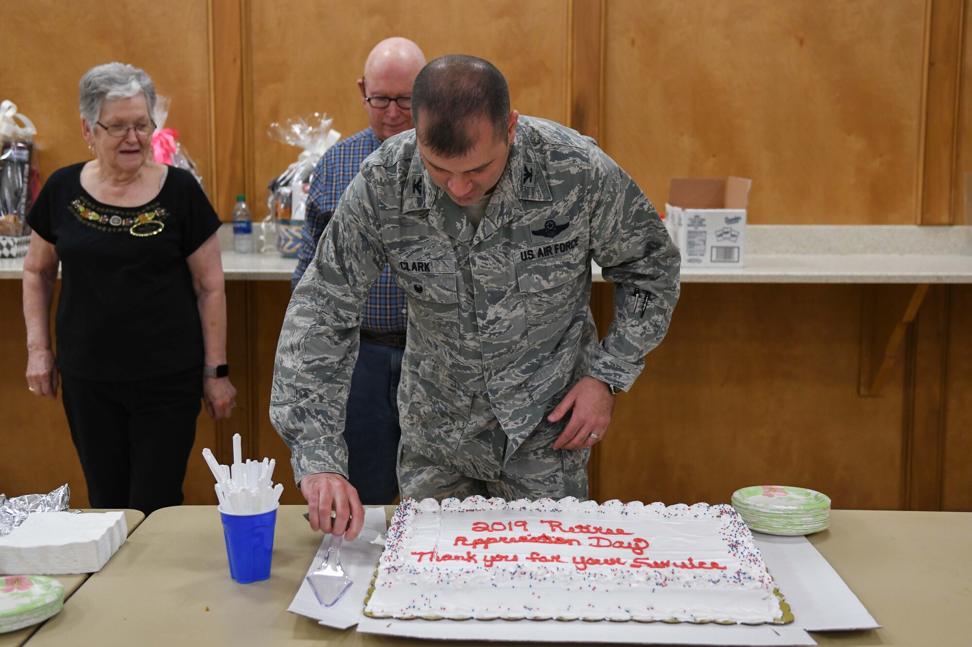 A man in uniform cuts a cake