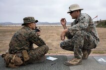Lance Cpl. Sean Blue, a Range Coach with Weapons and Field Training Battalion, corrects a recruits firing position during a table one live fire drill at Marine Corps Base Camp Pendleton, California Sept. 25, 2019.