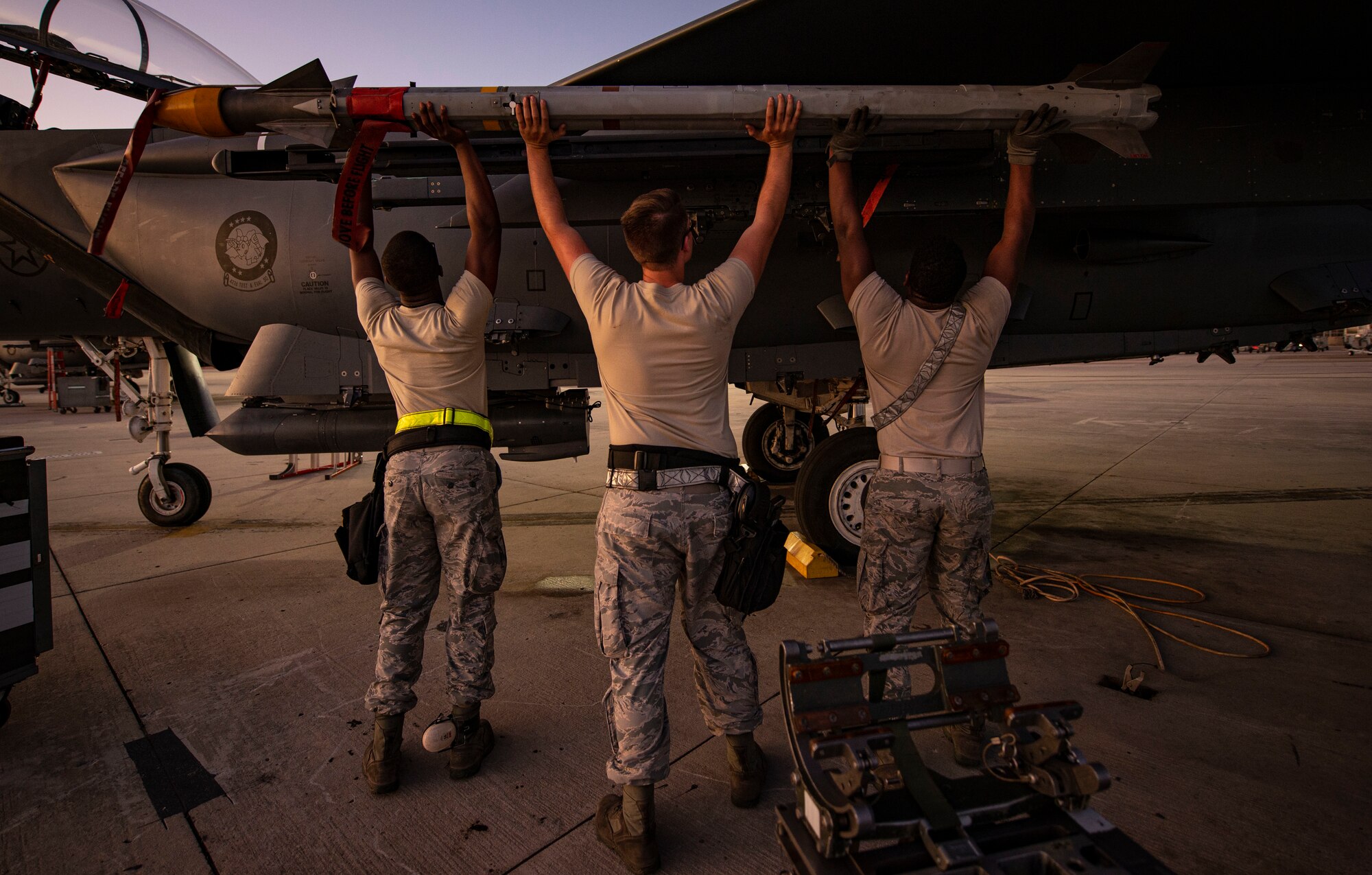 Three aircraft armament systems technicians assigned to the 757th Aircraft Maintenance Squadron load an AIM-9X Sidewinder missile onto an F-15E Strike Eagle fighter jet during Combat Archer 19-12 on Tyndall Air Force Base, Fla., Sept. 24, 2019. The AIM-9X system includes infrared-tracking, air-to-air and air-to-surface capabilities. (U.S. Air Force photo by Airman 1st Class Bailee A. Darbasie)