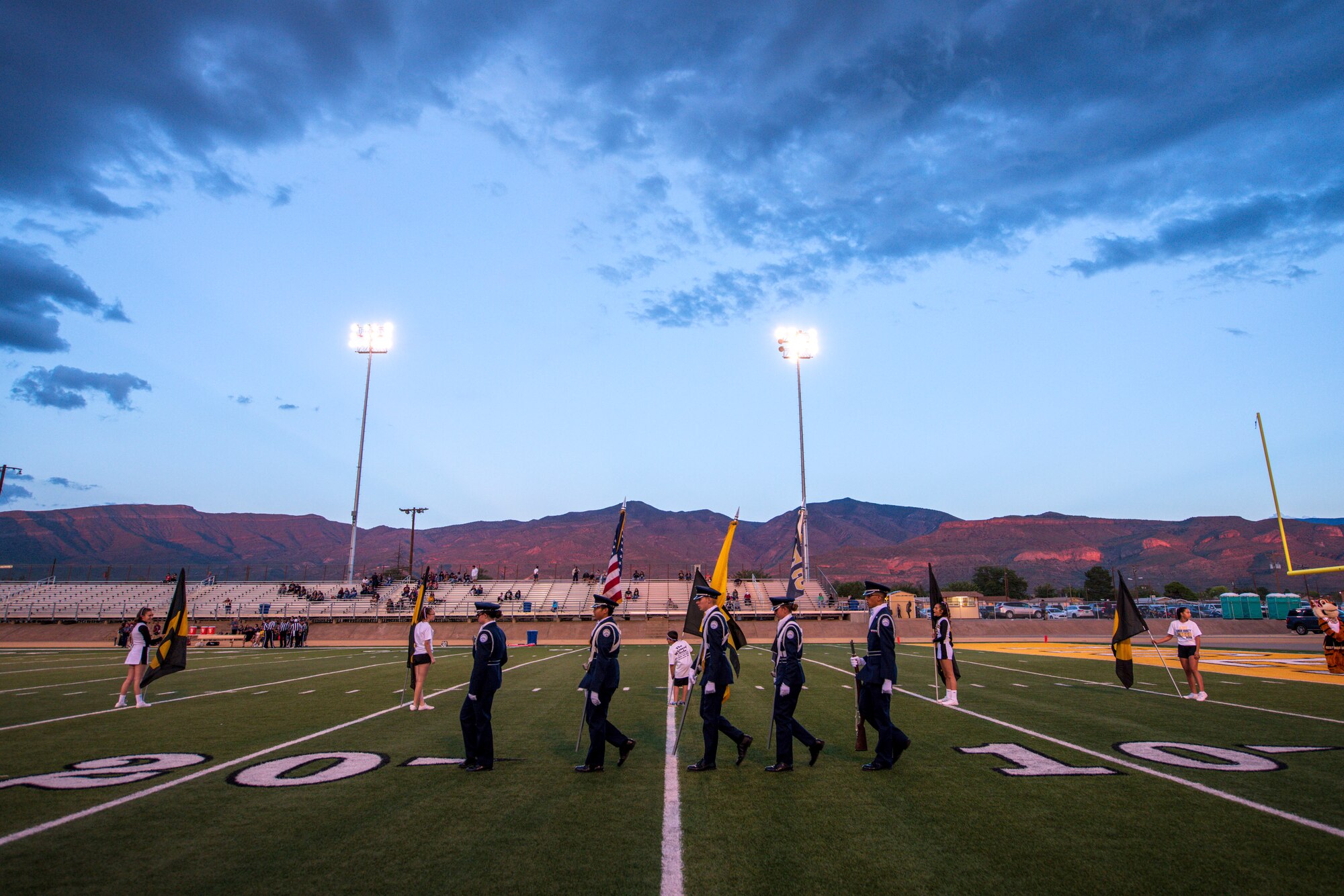 The Alamogordo High School Junior ROTC honor guard posts the colors prior to a AHS Military Appreciation Night football game, Sept. 27th, 2019, in Alamogordo, N.M. Holloman Air Force Base leadership was invited to the event to interact with the local community and enlist nine individuals into the Delayed Entry Program. (U.S Air Force photo by Staff Sgt. Christine Groening)