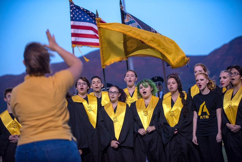 The Alamogordo High School Choir sings the National Anthem prior to an AHS Military Appreciation Night football game, Sept. 27th, 2019, in Alamogordo, N.M. Holloman Air Force Base leadership was invited to the event to interact with the local community and enlist nine individuals into the Delayed Entry Program. (U.S. Air Force photo by Staff Sgt. Christine Groening)
