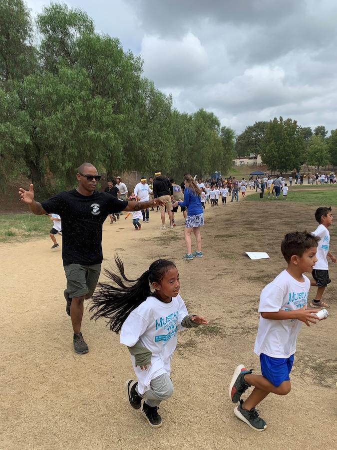 U.S. Marine Staff Sgt Kevin Porter ,left, a transmissions chief from 3rd Low Altitude Air Defense Battalion (LAAD), 3rd Marine Aircraft Wing (MAW) runs with and encourages children from Maie Ellis Elementary in Fallbook, Calif., Sept. 27. Marines paced the students around the track and showed them the importance of maintaining a "never quit" attitude.  More than 500 students ran laps as part of the school's fundraising efforts toward reading programs and after-school activities. Marines from 3rd MAW always take great pride in interacting with and supporting the local community. (U.S. Marine Corps photo courtesy of 3rd Low Altitude Air Defense Battalion)