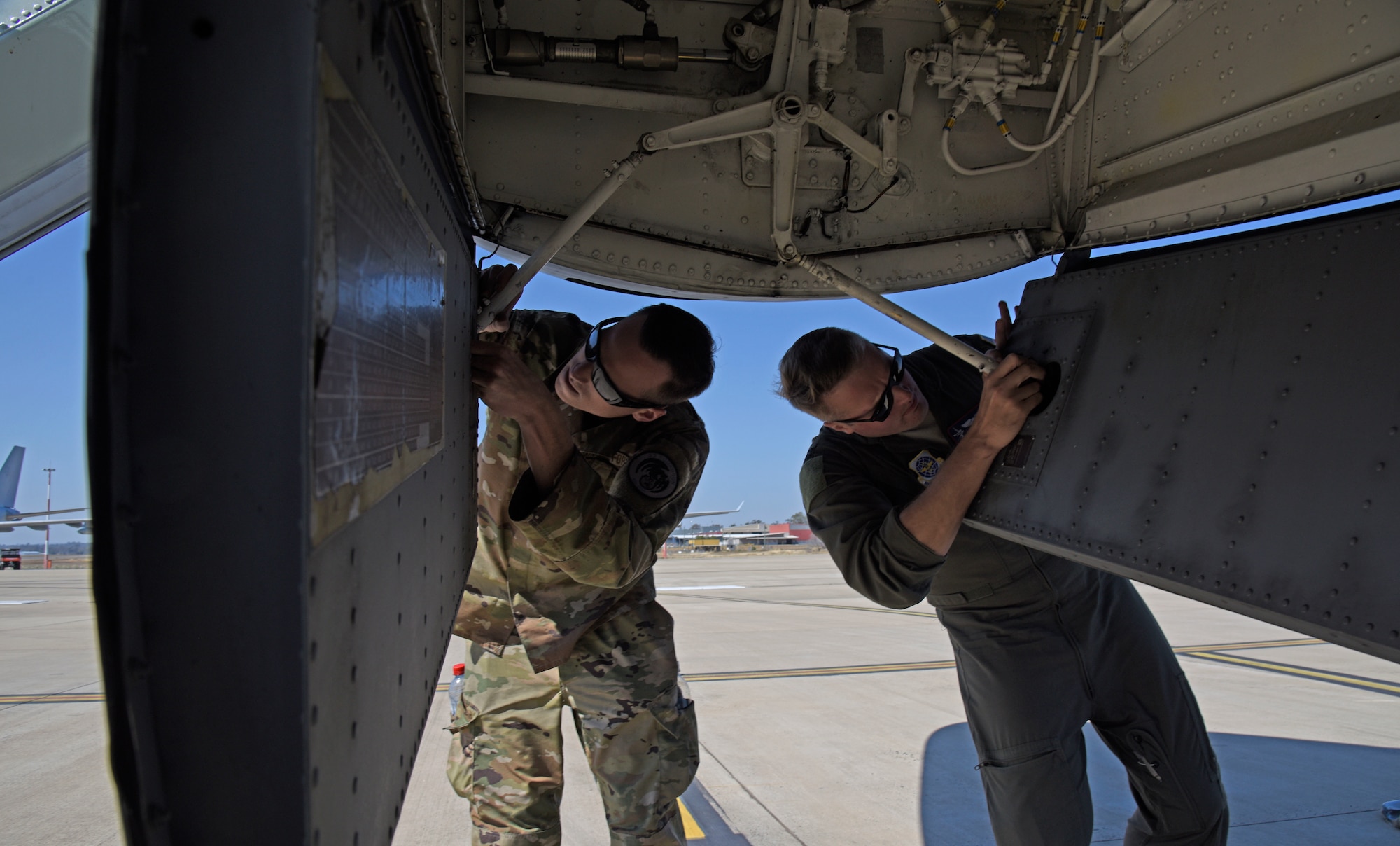 U.S. Air Force Senior Airman Eli Young, 92nd Aircraft Maintenance Squadron flying crew chief, and Capt. Ryan Turner, 93rd Air Refueling Squadron KC-135 Stratotanker pilot, open the nose landing gear door for a preflight inspection at Royal Australian Air Force Base Amberley, Australia, Sept. 15, 2019. Turner is in the final stages of completing his aircraft commander upgrade program and prepares for final evaluation as he leads mission planning during a temporary deployment.  (U.S. Air Force photo by Senior Airman Jesenia Landaverde)