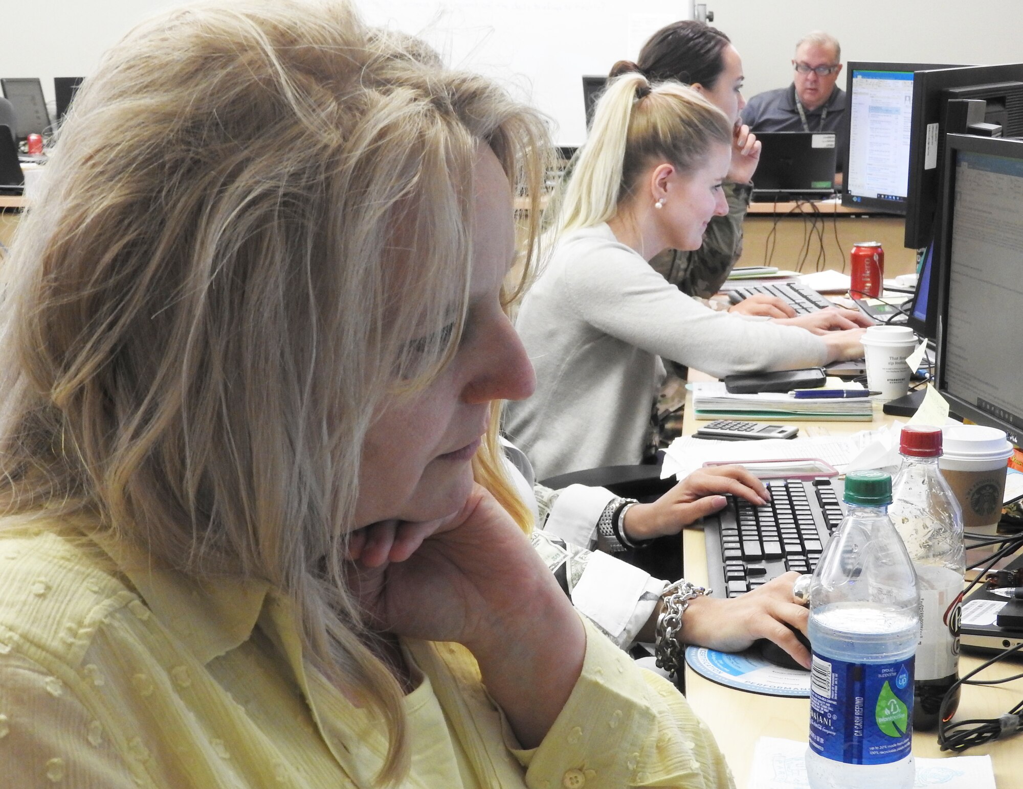 Lisa Cupp, AFIMSC Detachment 10 resources division chief, updates spreadsheets after phone discussion with the Malmstrom AFB, Mont., comptroller. (Air Force photo by Ed Shannon)