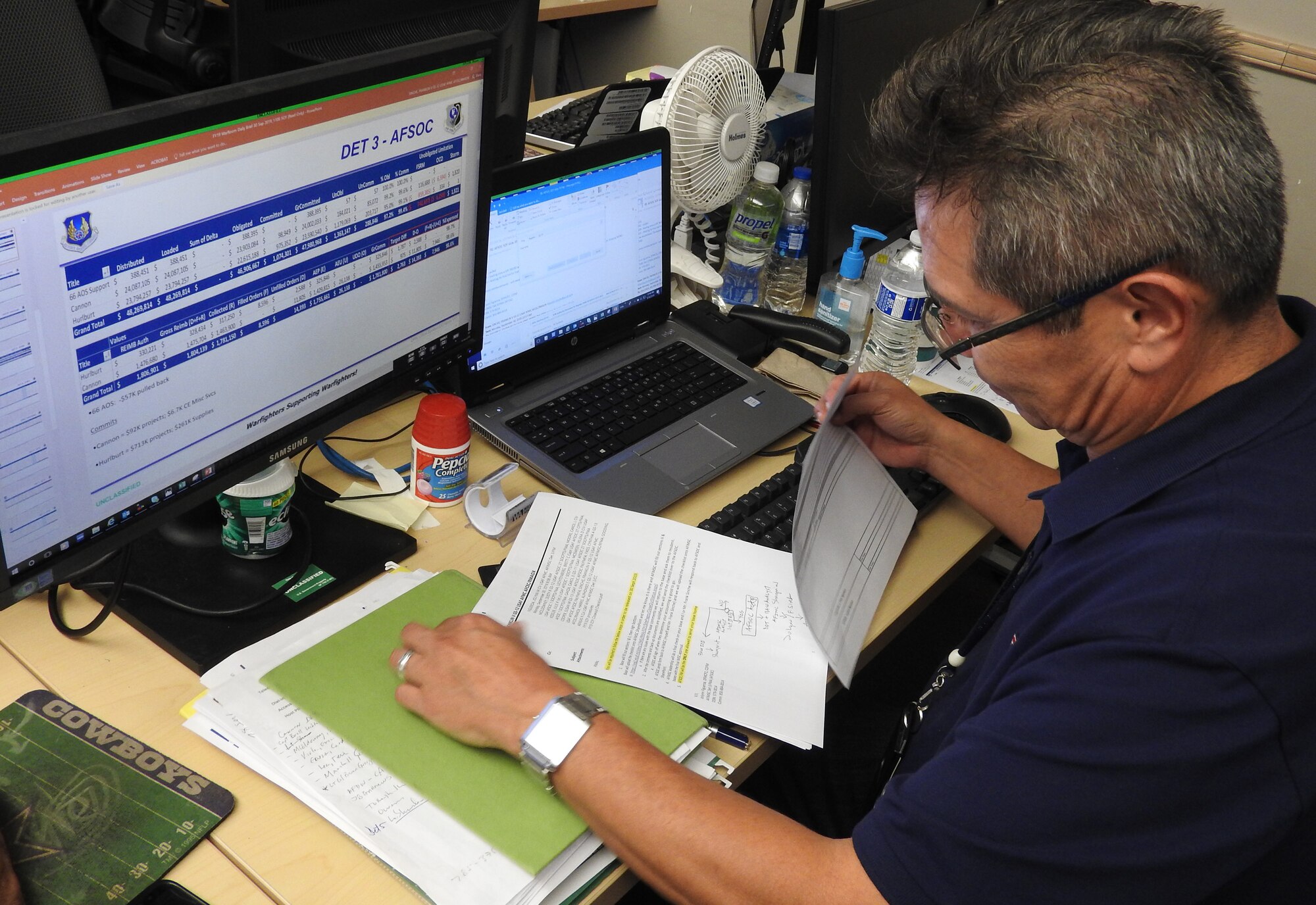 Frank Sinche, an AFIMSC base analyst for Air Force District of Washington and Air Force Special Operations Command units, reviews funding requirements in preparation for briefing members of the war room on closeout status. (Air Force Photo by Ed Shannon)