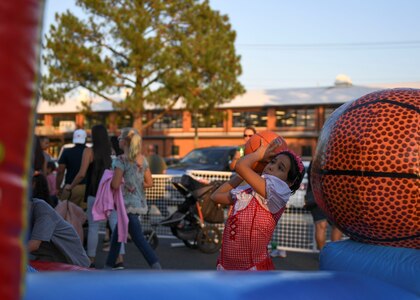 A young girl shoots a basketball during an Oktoberfest celebration at Joint Base Langley-Eustis, Virginia, Sept. 27, 2019.